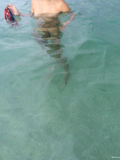 Молоденькая светловолосая красотка обнаженная купается в лазурном море